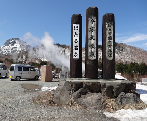 平床大噴泉から立ち上る白い湯気と石碑