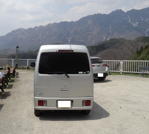 大望峠の展望台と軽キャンピングカーの後ろ姿、遠くに見える山並み