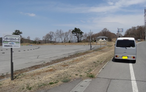 RVパーク斑尾高原の看板と道路脇の軽キャンピングカー